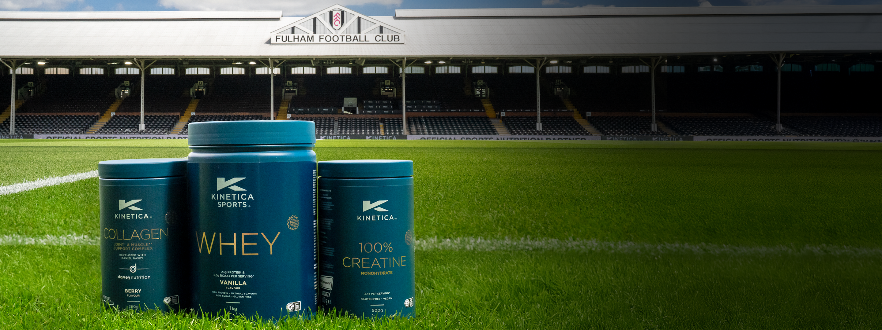 Blue protein powder containers on a football field with stadium in the background